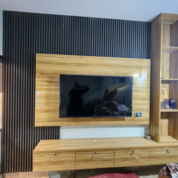Modern media wall interior design with TV panel, built-in storage, warm lighting, and stylish living room decor.