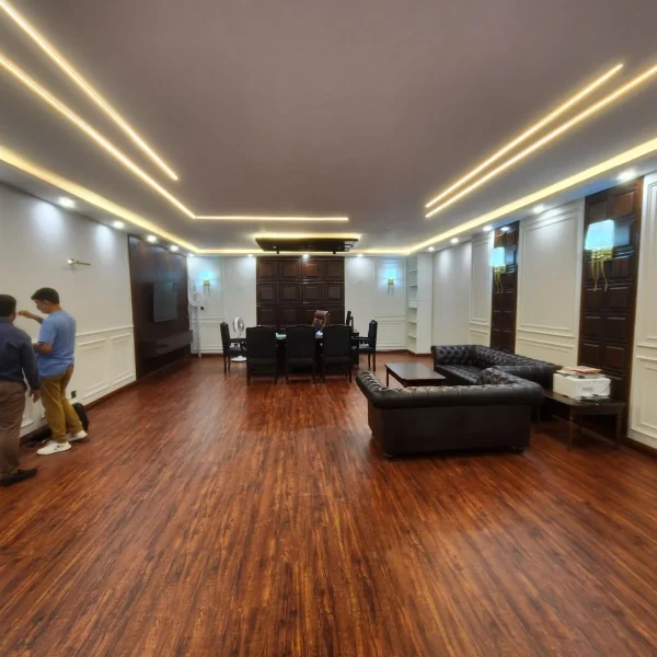 Office interior design at Custom House Karachi with wood-finish flooring, wall moulding and modern ceiling lights by Identity Interior