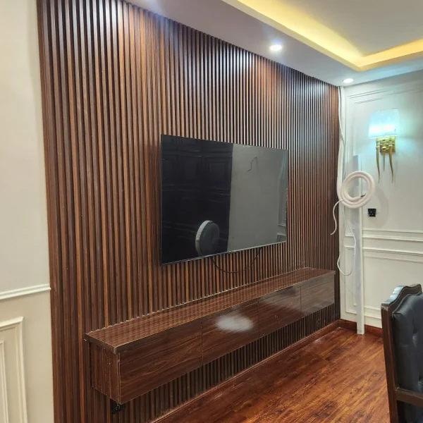 Wooden slat TV media wall with floating console designed by Identity Interior at Custom House Karachi